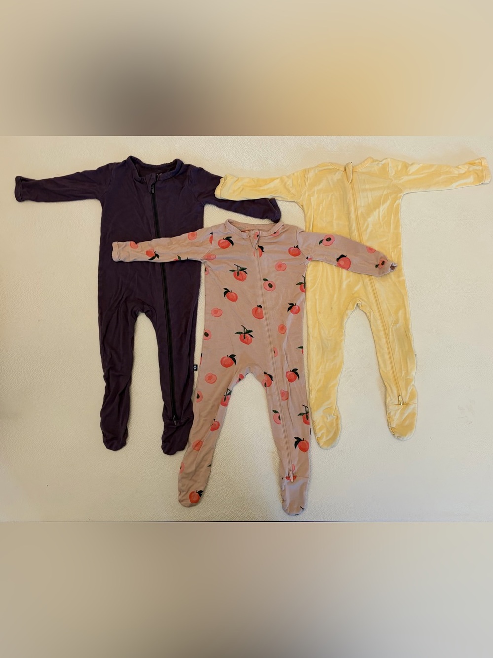 Kyte Baby Footie Zipper Pajamas TRIO. Purple, Peach Print, Yellow. 6-12mo
